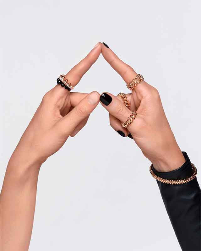 Imagem de mãos usando anéis Cartier uma das top marcas mais caras do mundo.