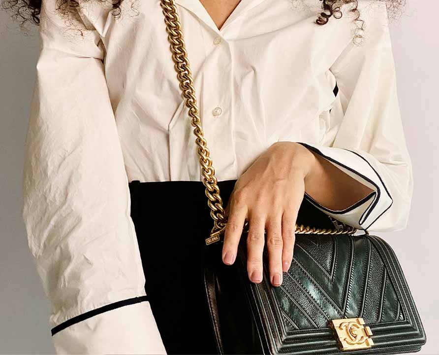 Foto de uma mulher usando uma bolsa transversal da Chanel, modelo crossbody Boy.
