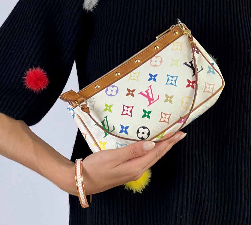 Foto de mulher segurando bolsa Louis Vuitton.
