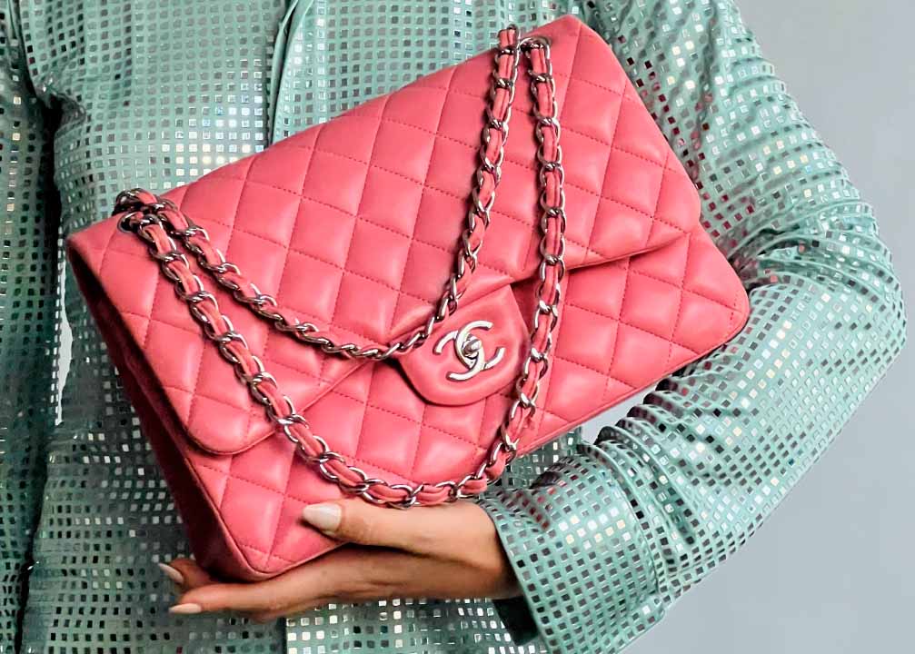 Foto de mulher segurando bolsa Chanel em tons pastéis provando que candy colors bags é uma tendência forte.