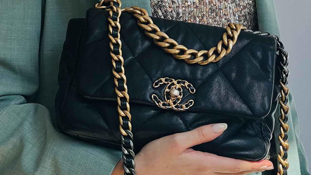 Foto de uma mulher segurando uma Bolsa da Chanel.