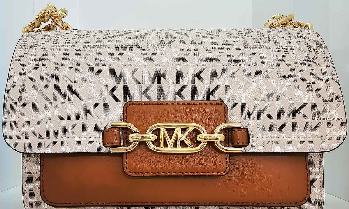 Foto de uma bolsa com monograma Michael Kors, o nome da marca MK.