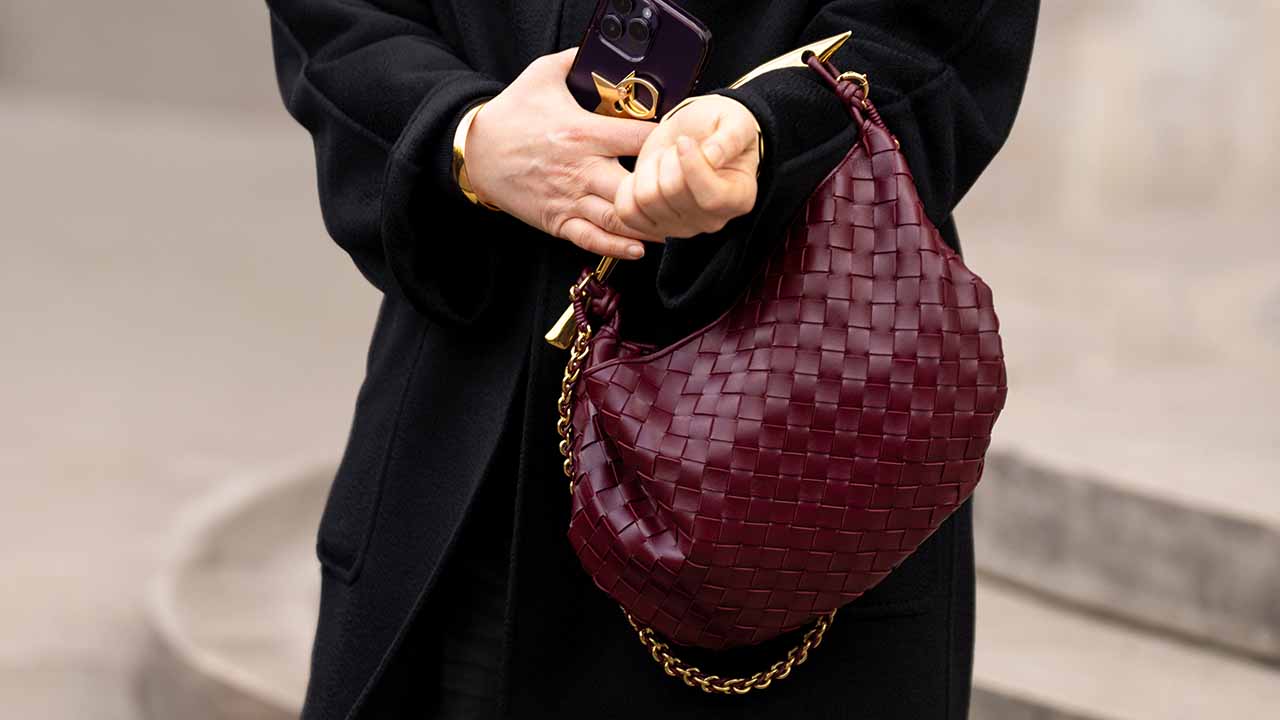Foto de mulher carregando bolsa Bottega Veneta.