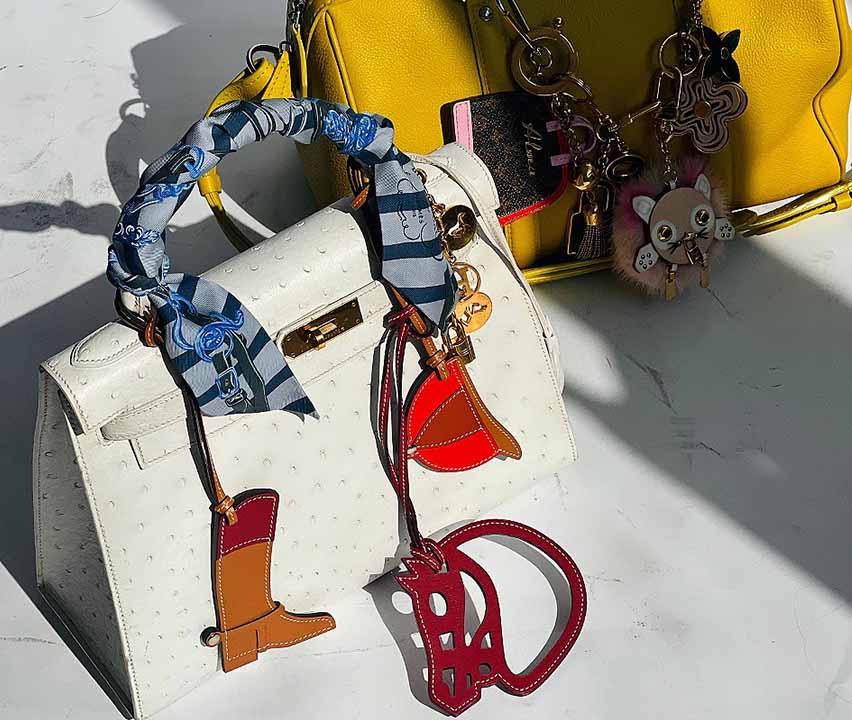 Foto de bolsas de luxo com acessórios pendurados, os bag charms,estilo chaveiro de bolsa.