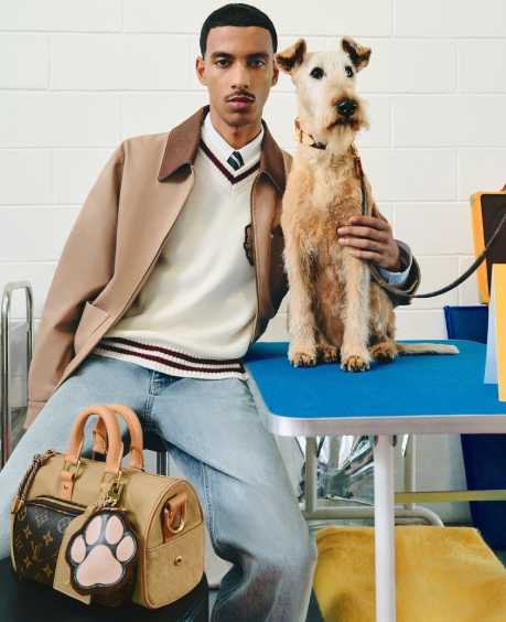 Foto de uma Campamha Masculina da Louis Vuitton: modelo ao lado de um cachorro da raça Fox Terrier que inspira a nova bolsa da marca.