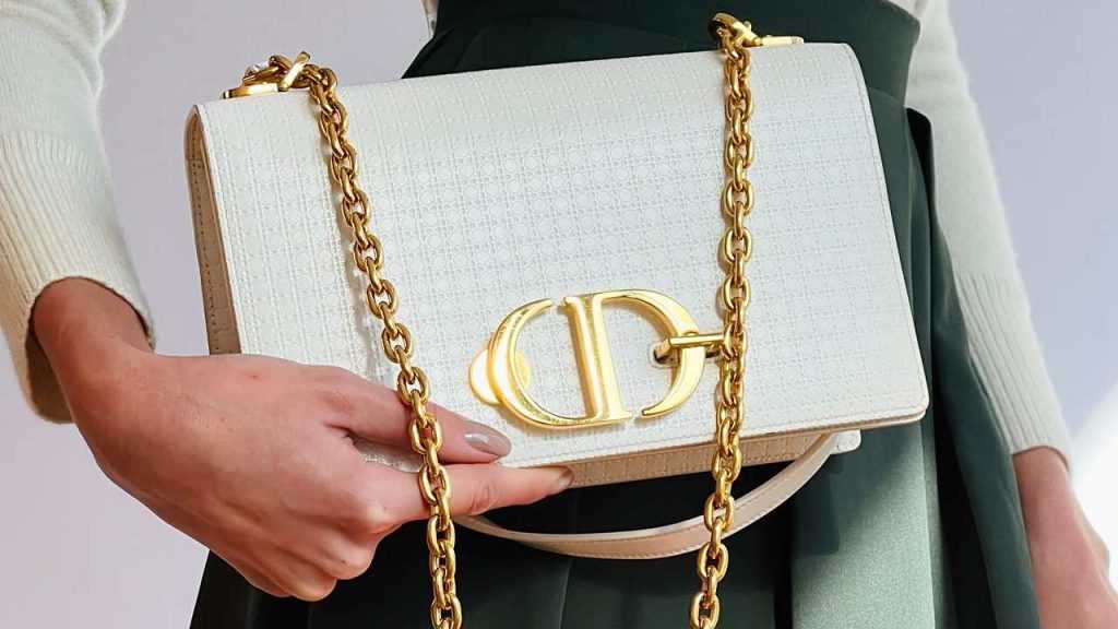 Foto de mulher seguranca a bolsa 30 montaigne da marca de luxo Dior.