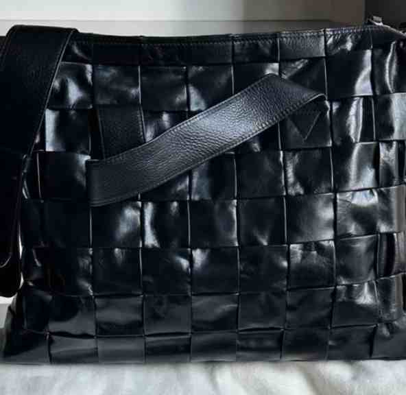 Foto de uma bolsa da marca de luxo bottega veneta na cor preta.