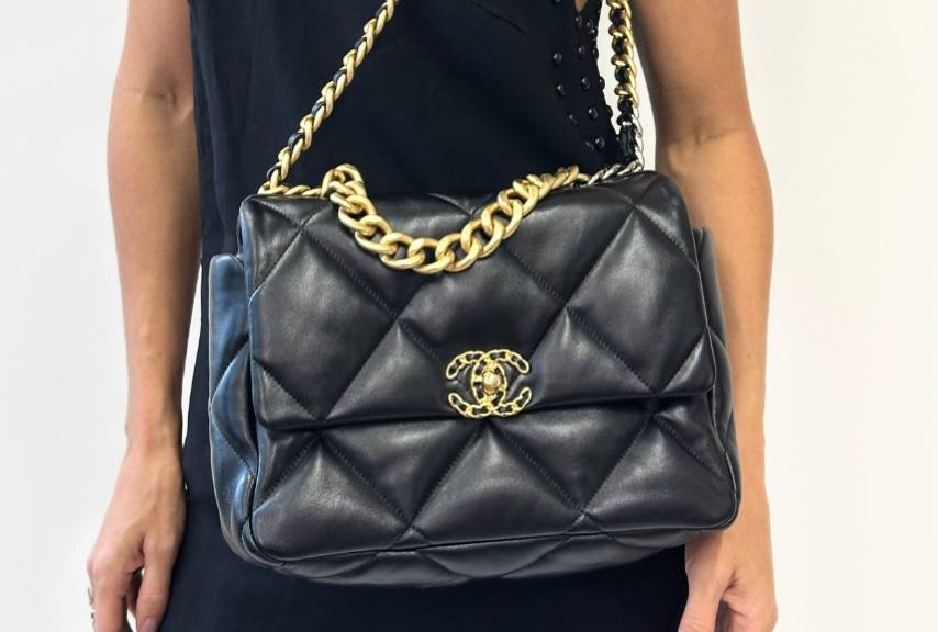 Foto de mulher usando a Chanel 19, um dos estilos de bolsas Chanel mais modernos com alça robusta e matelassê maior.