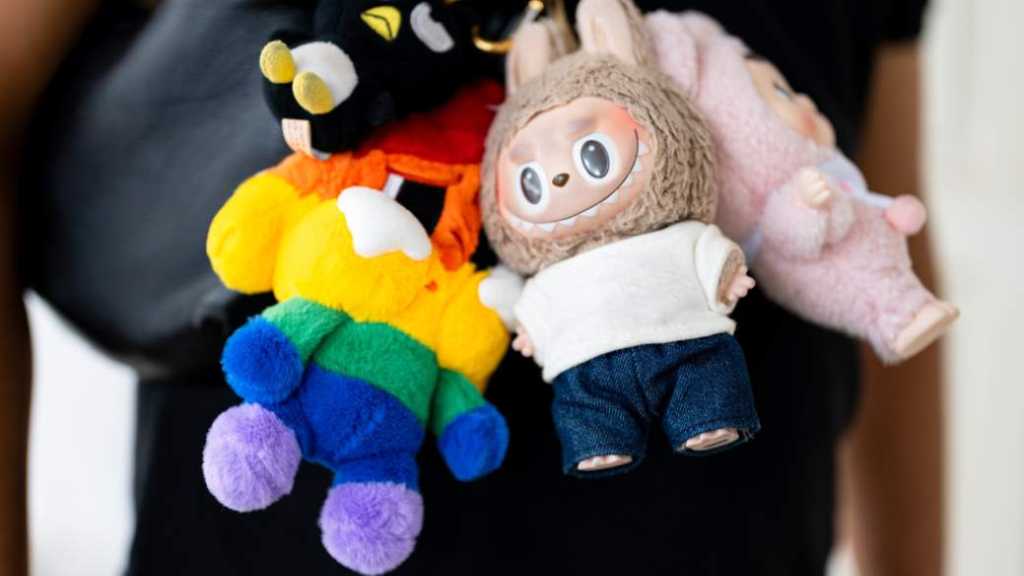Foto de Labubus em bolsas de luxo.
