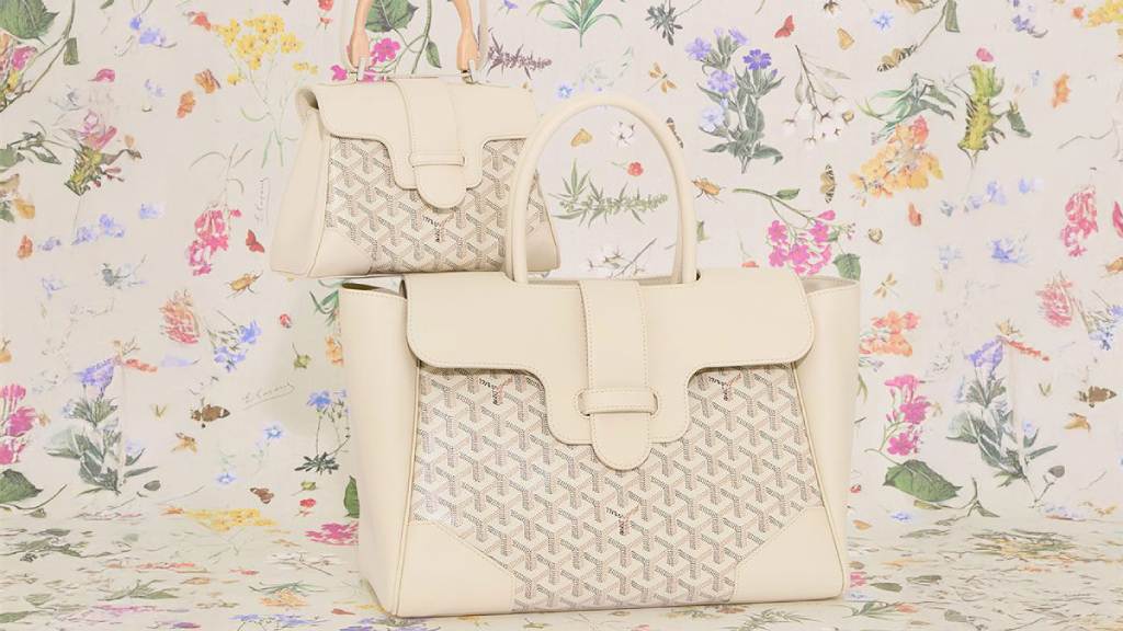 Foto da nova cor da Goyard aplicada nos modelos famosos Saigon com fundo floral que apareça no forro dos acessórios de luxo limitados.