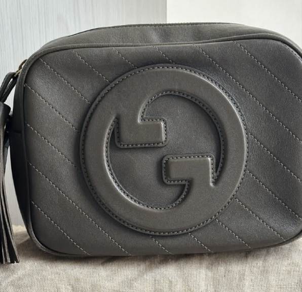 Foto de uma das bolsas gucci em couo cinza escuro que combina com look invernal.