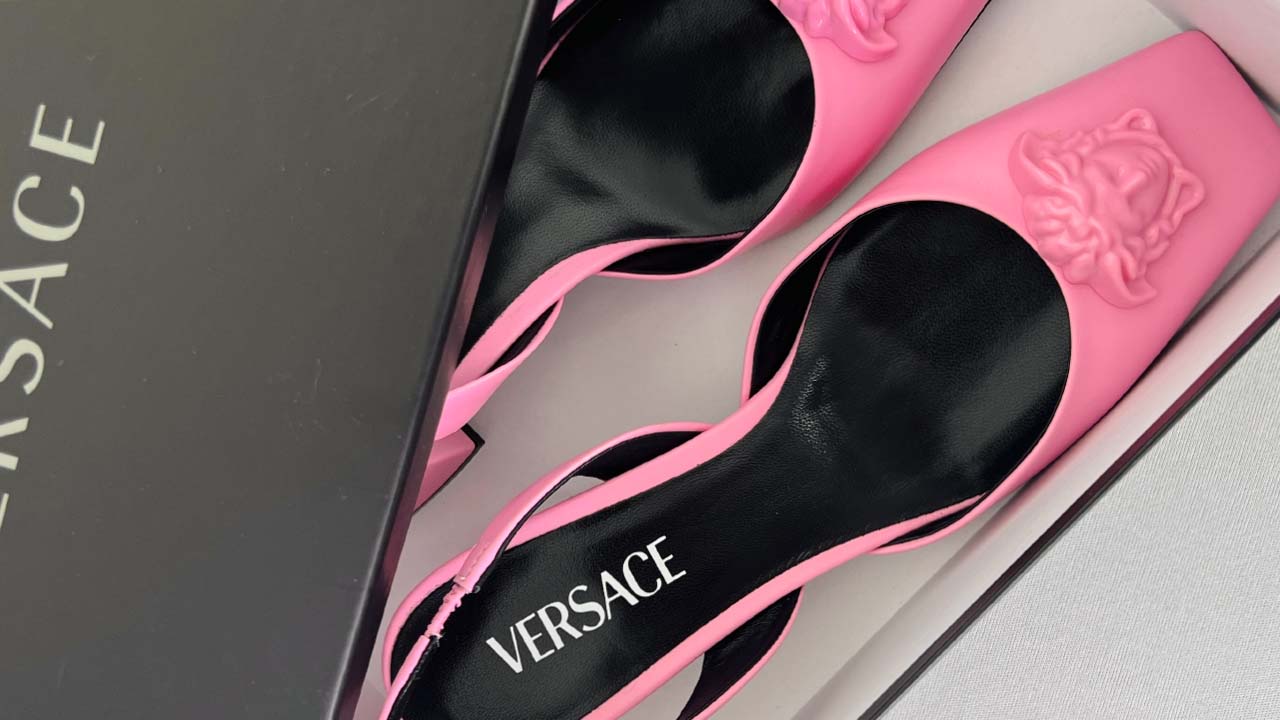 Foto de apatos Versace com a icônica medusa, símbolo da grife.