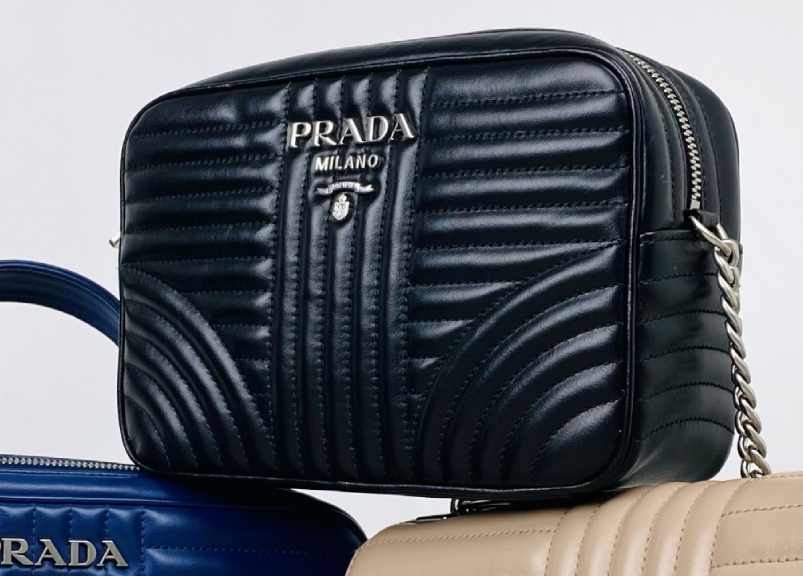 Foto de bolsa prada com alça linga e formato quadrado.