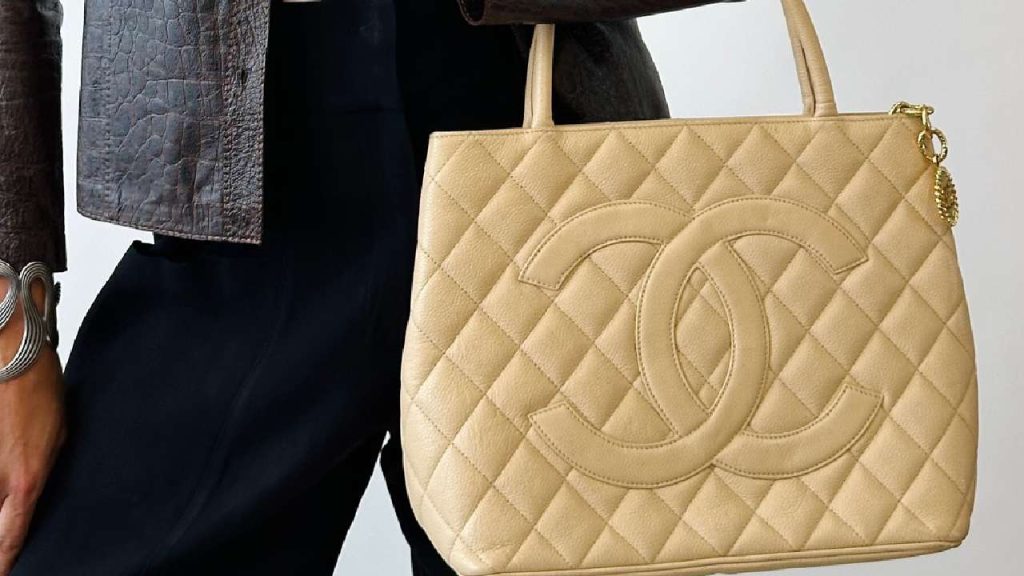 Foto de mulher segurando bolsa de luxo.