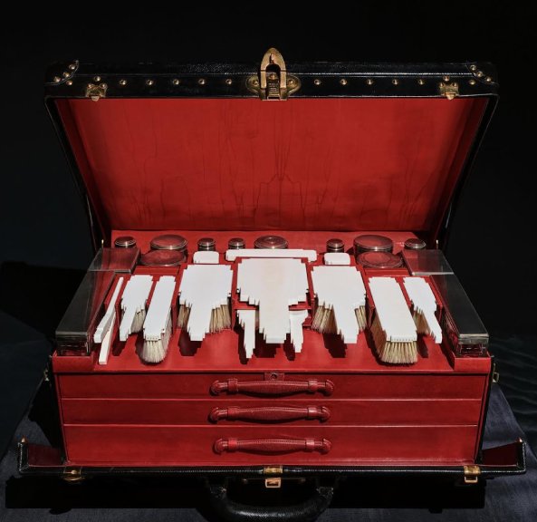 Foto de baú de viagem da Louis Vuitton em exposição.