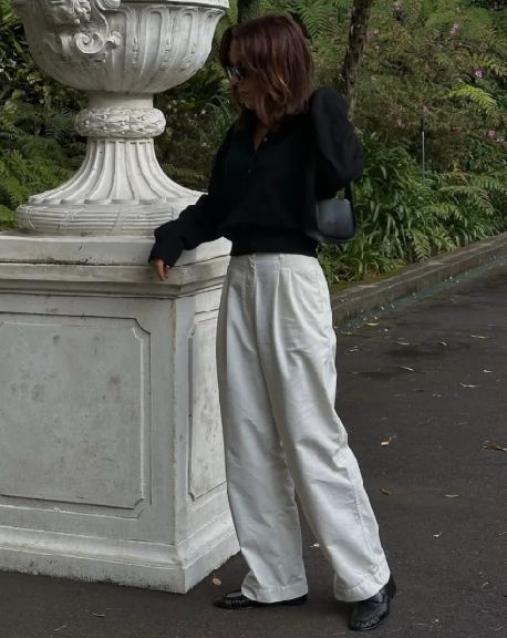Foto de mulher mostrando como combinar mocassim com calça ampla.