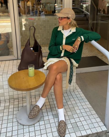 Foto de mulher usando mocassim com meias brancas.