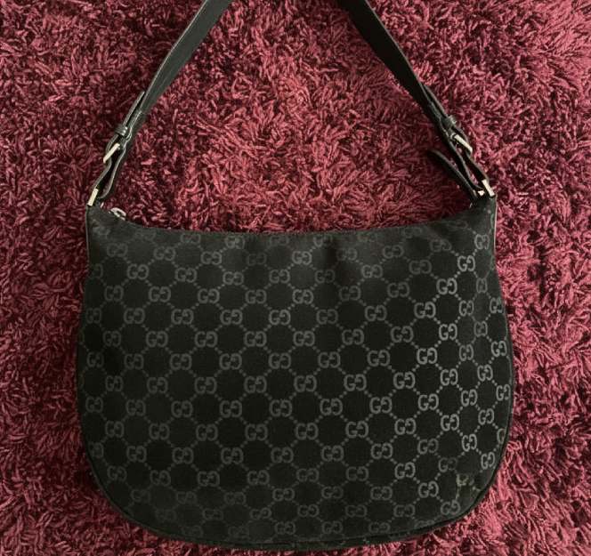 Foto de uma bolsa Gucci com monogramas e estilo hobo bag..