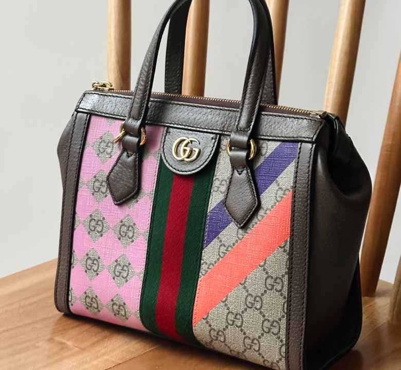 Foto de uma bolsa nasa básica da Gucci cheia de estampa colorida.