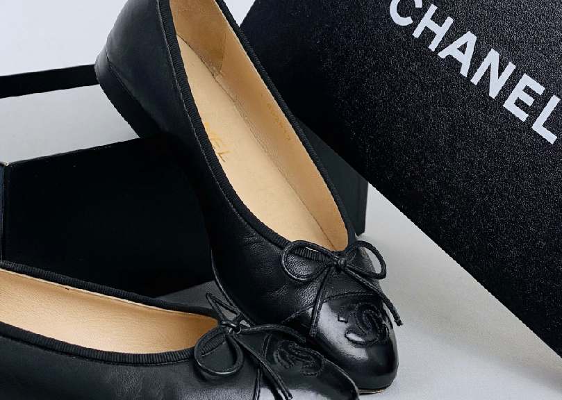 Foto de sapatilha Chanel com bico redondo de verniz.