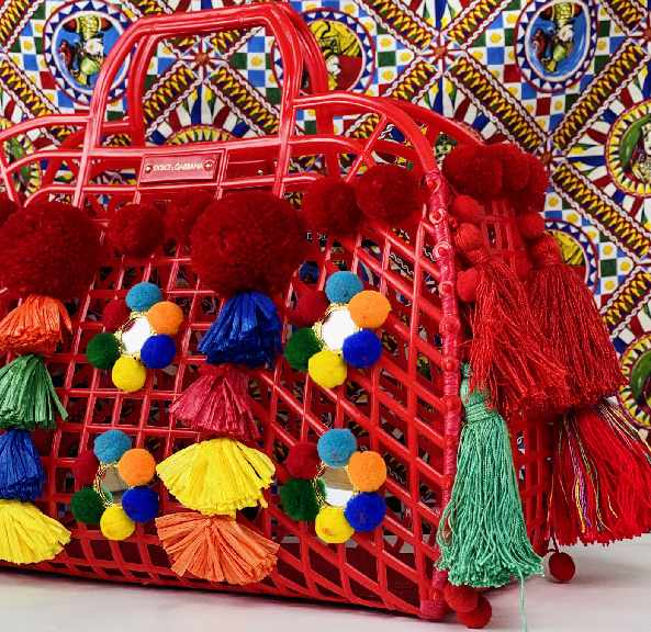 Foto de bolsa dolce e gabbana em formato de cesta e detalhes de pompons coloridos a carão do verão.