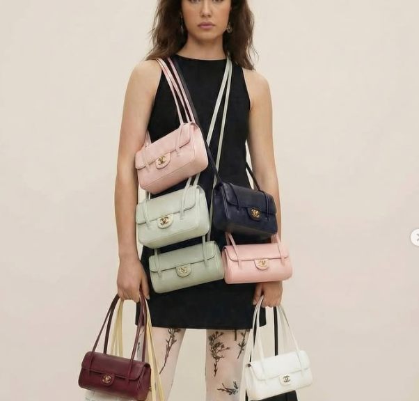 Foto de modelo com várias bolsas da Chanel coloridas.