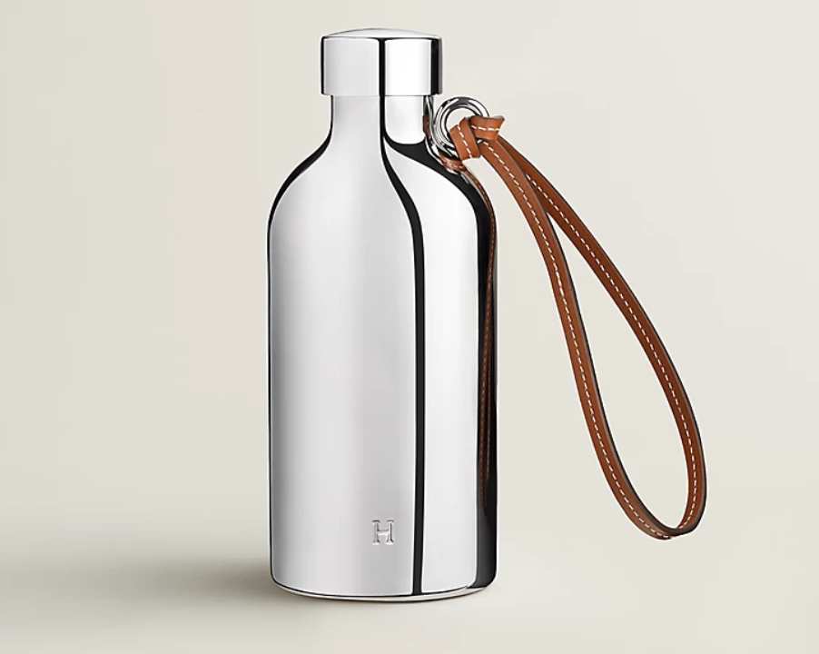 Foto da garrafa de água da Hermès com alça de couro.