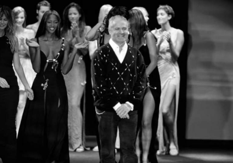 Foto de Gianni Versace encerrando um desfile.