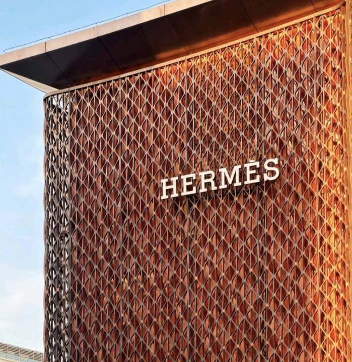 Foto da  fachada em malha metálica artesanal  que traduz o DNA da Hermès e transforma a loja em um dos novos marcos do luxo em Pequim.
