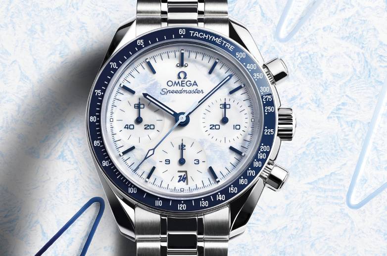 Omega Speedmaster 38mm Milano Cortina 2026 no pulso — caixa de 38mm em aço inoxidável com luneta azul