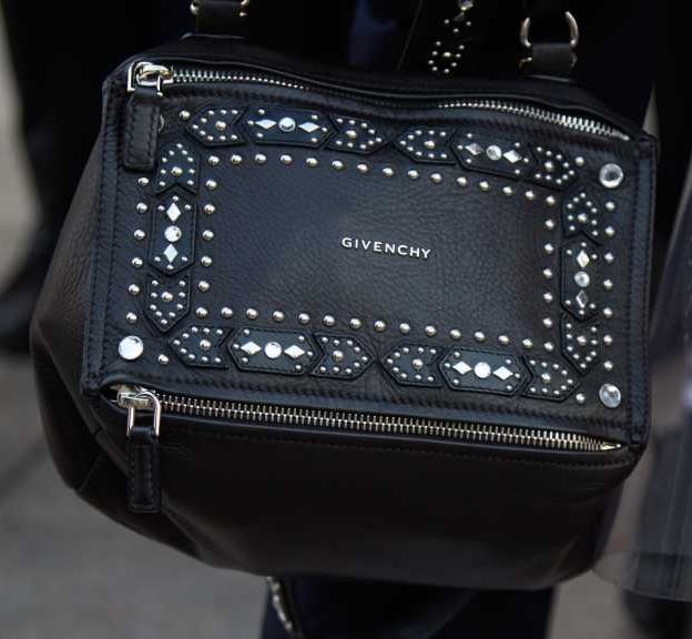 Bolsa de luxo da marca givenchy sendo carregada nas ruas..