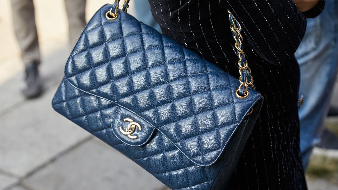 Mulher carregando bolsa chanel feita de couro caviar.