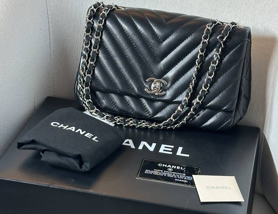 Bolsa Chanel Clássica com cartão de autenticidade seminova no mercado de resale de luxo.